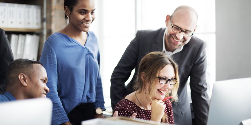 Diverse marketing team collaborating around a computer